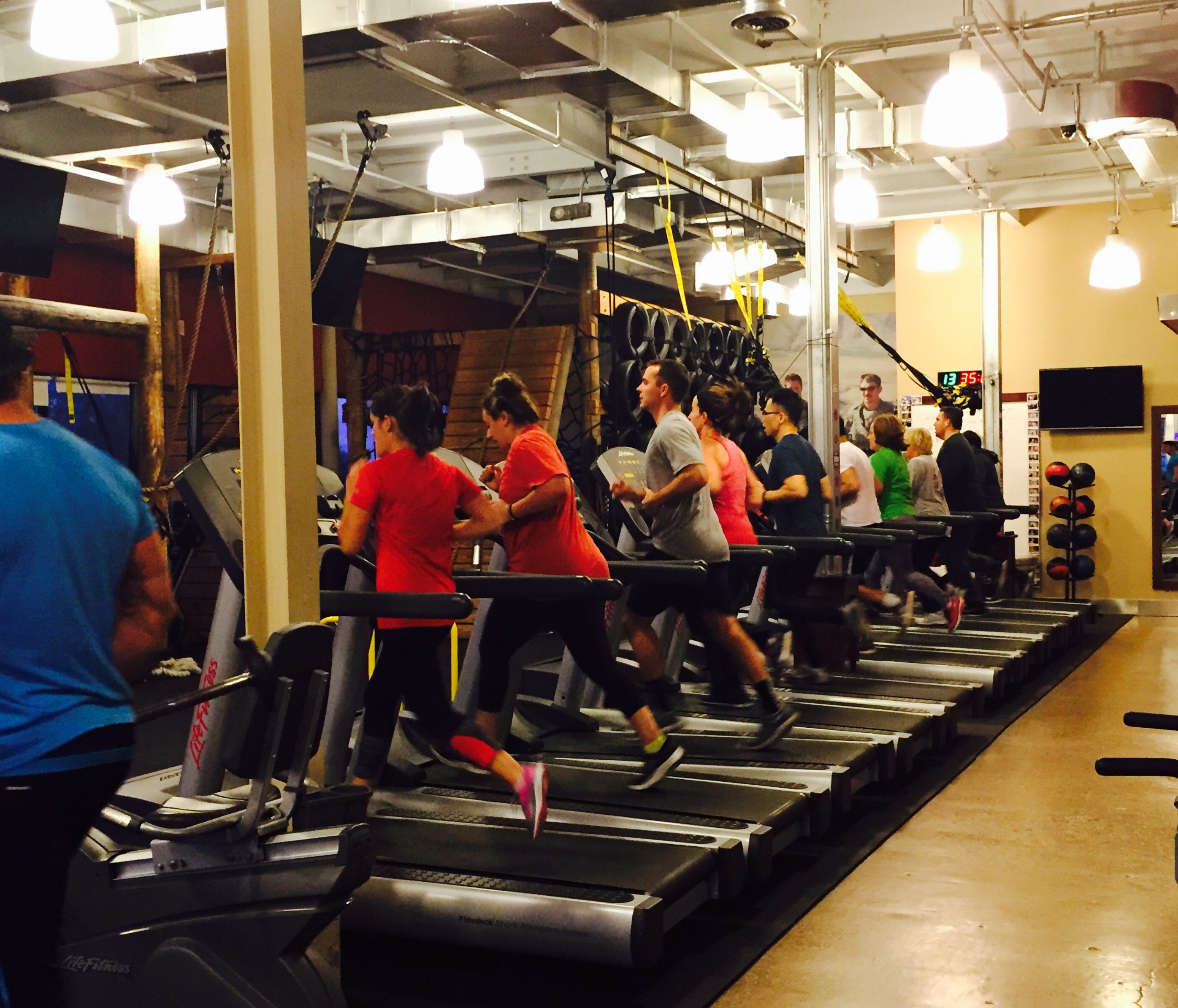 Members running on treadmills during class
